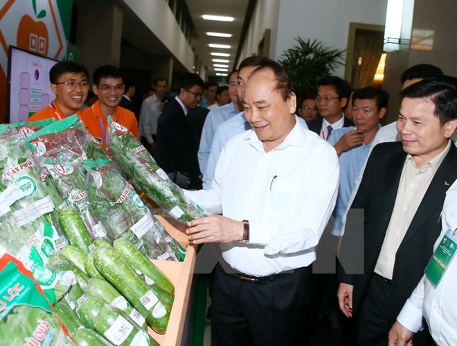 Thủ tướng Nguyễn Xuân Phúc thăm gian hàng trưng bày tại hội nghị. (Ảnh: Thống Nhất/TTXVN)