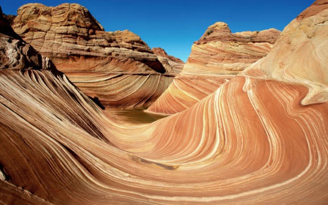 Những đụn cát hóa thạch với những họa tiết hình lượn sóng tuyệt đẹp tại khu bảo tồn Coyote Buttes, nằm giữa biên giới giữa bang Arizona và Utah, Mỹ. Những cấu trúc này được tạo ra do tác động của gió và mưa trong quá trình kéo dài hàng triệu năm.