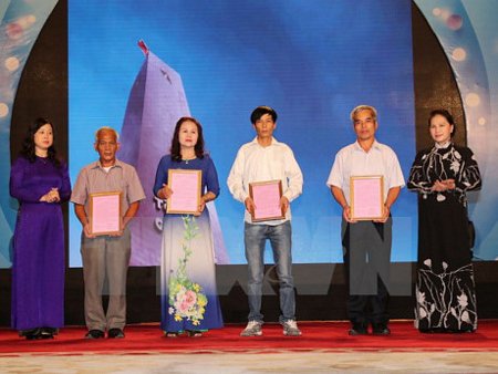 Chủ tịch Quốc hội Nguyễn Thị Kim Ngân trao kết quả giám định ADN cho thân nhân liệt sỹ. (Ảnh: Trọng Đức/TTXVN)