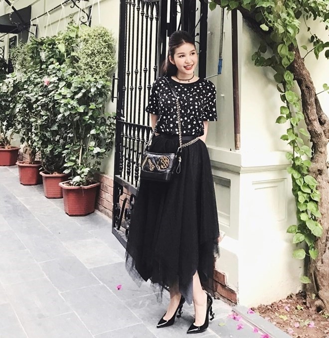 Cũng bắt cặp chân váy đen và áo phông, cô nàng Trang Vũ lại chọn giày cao gót cùng tông của Saint Laurent làm phụ kiện điểm trang nét nữ tính.