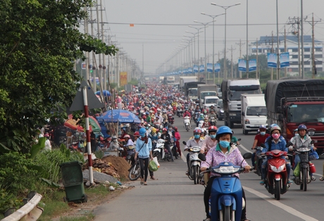 Mua bán lấn chiếm lòng lề đường trước KCN Hòa Phú gây cản trở giao thông vào giờ tan tầm.
