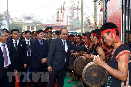 Thủ tướng Nguyễn Xuân Phúc với các nghệ nhân biểu diễn nghệ thuật cồng chiêng tại Triển lãm di sản văn hoá Sâm Ngọc Linh Kon Tum. (Ảnh: Thống Nhất/TTXVN