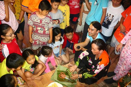 Tiêu Minh Sơn cùng các em trải nghiệm cái Tết truyền thống từ việc xem và học gói bánh tét.