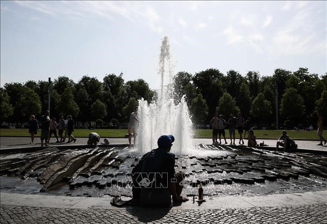 Người dân giải nhiệt tránh nóng tại một đài phun nước ở Berlin, Đức ngày 25/7/2019. Ảnh: THX/TTXVN