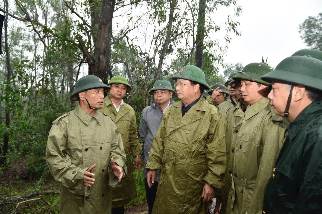 Tư lệnh Quân khu 4 Nguyễn Doãn Anh (bìa trái) báo cáo tình hình tìm kiếm cứu nạn với Phó Thủ tướng Trịnh Đình Dũng (giữa) tại huyện Phong Điền, Thừa Thiên Huế, chiều 13/10. Ảnh: VGP/Nhật Bắc
