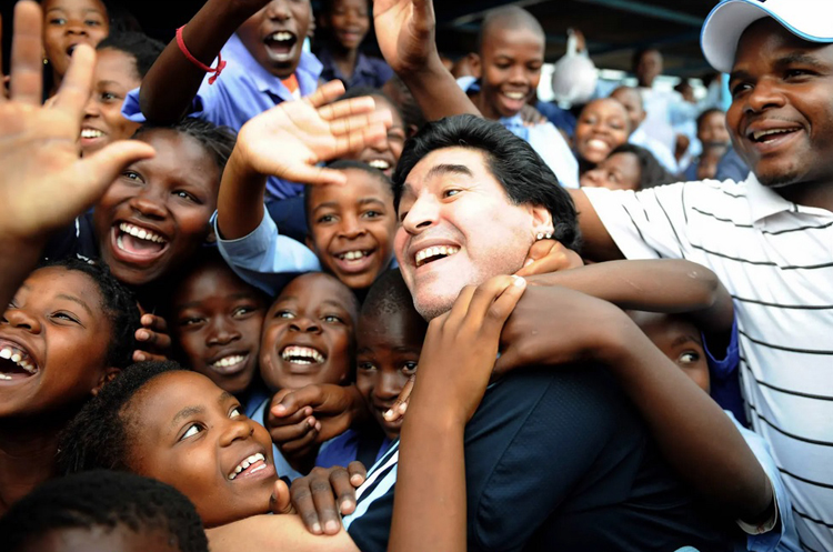 Các học sinh hân hoan khi Maradona đến thăm một trường học ở Nam Phi tháng 1/2010. Ở thời điểm này ông giữ vai trò huấn luyện viên đội tuyển Argentina. Ảnh: Getty Images