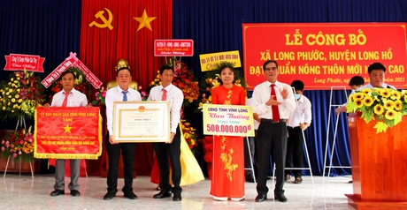 Ông Lê Quang Trung- Phó Chủ tịch Thường trực UBND tỉnh trao cờ thi đua, bằng công nhận đạt chuẩn NTM nâng cao và khen thưởng công trình phúc lợi trị giá 500 triệu đồng cho xã Long Phước.