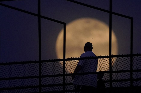 Một người đàn ông và em nhỏ ngắm siêu trăng tại Indiana (Mỹ). Ảnh: AP