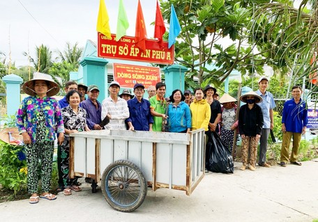 Bà Huỳnh Ngọc Mai (đứng giữa) cùng mọi người ra quân thực hiện mô hình “Dòng sông xanh” và dọn dẹp cảnh quan môi trường.