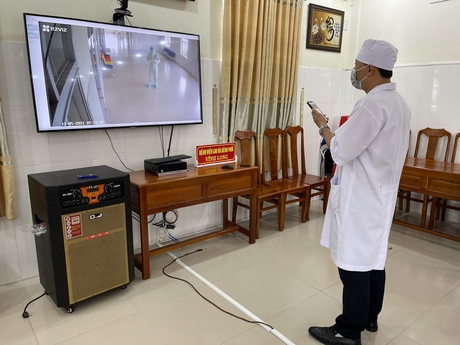 Liên lạc với bác sĩ điều trị bệnh nhân COVID-19 tại khu cách ly của Bệnh viện Phổi Vĩnh Long thông qua hệ thống camera. Ảnh: THÚY QUYÊN