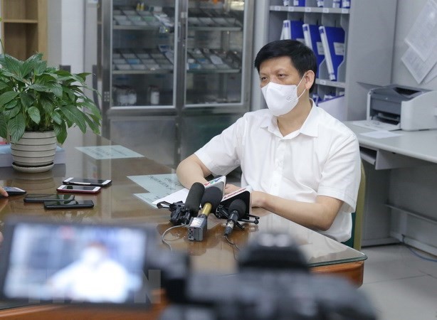 Bộ trưởng Nguyễn Thanh Long trả lời phỏng vấn báo chí sau tiêm. (Ảnh: Hoàng Hiếu/TTXVN)