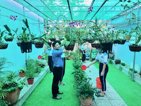 Thầy hiệu trưởng Nguyễn Tấn Lập cùng học sinh chăm sóc không gian xanh- sạch- đẹp của trường.