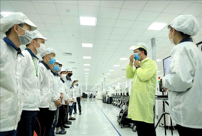 Công ty TNHH Compal Việt Nam trong khu công nghiệp Bá Thiện 1 (huyện Bình Xuyên, tỉnh Vĩnh Phúc) hướng dẫn cho công nhân đeo khẩu trang đúng cách để phòng dịch COVID- 19. Ảnh: Hoàng Hùng/TTXVN.