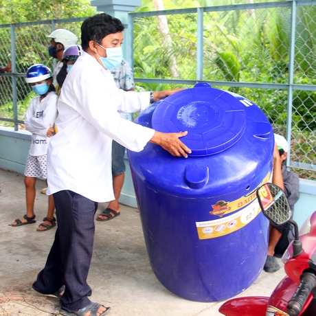 Người dân ở xã Hòa Hiệp (Tam Bình) nhận bồn chứa nước ứng phó với hạn mặn mùa khô 2019- 2020. 