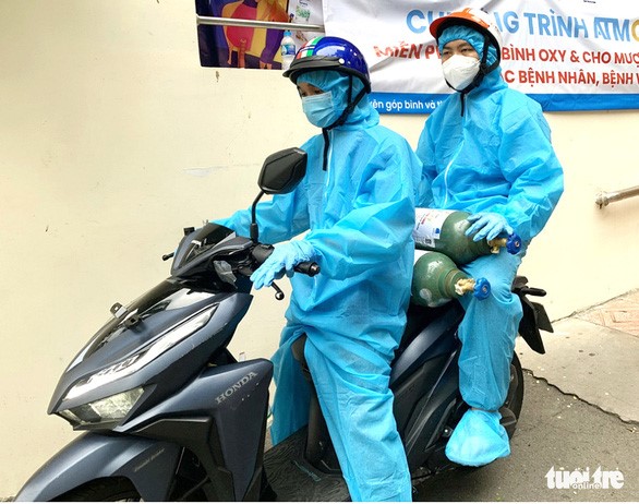 Các tình nguyện viên quận Tân Phú (TP.HCM) chuyển ngay bình oxy trong dự án ATM oxy đến bệnh nhân trên địa bàn quận - Ảnh: Q.L.