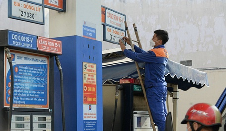 Nhân viên gắn lại giá xăng mới tại một cây xăng ở quận 4, TP.HCM. Ảnh chụp lúc 15g chiều 1/3 - Ảnh:T.T.D.