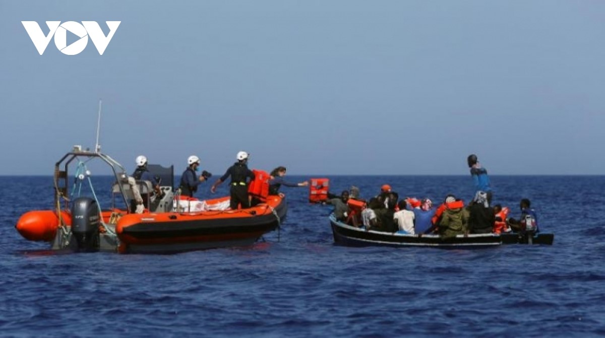 Lực lượng cứu hộ giúp đỡ những người di cư trên một chiếc thuyền nhỏ ở ngoài khơi Libya (Ảnh: aawsat)