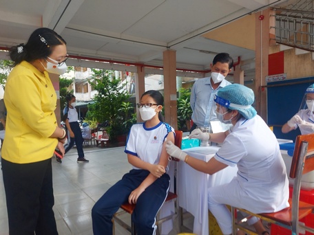 Phó Chủ tịch UBND tỉnh động viên tinh thần em Lê Thiên Kim- học sinh đầu tiên tiêm vắc xin tại Trường THCS Lê Quý Đôn (TP Vĩnh Long).