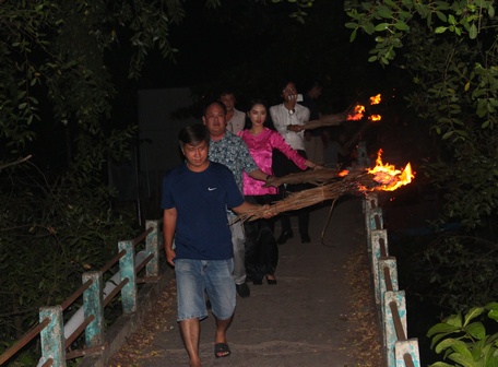 Du khách trải nghiệm đốt đuốc lá dừa đến đình An Thành.