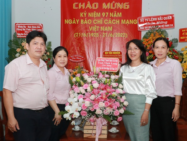 Phó Tổng Biên tập Lê Ngọc Thúy nhận hoa chúc mừng từ Ngân hàng Chính sách xã hội chi nhánh tỉnh Vĩnh Long