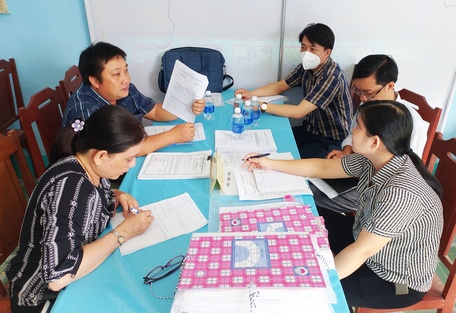 Các thành viên của đoàn khảo sát kiểm tra hồ sơ thực hiện các tiêu chí của xã Tân Long Hội.
