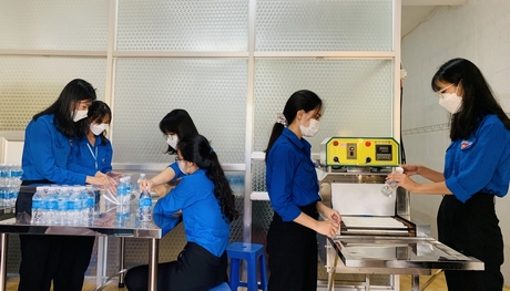 Sinh viên Trường ĐH Sư phạm kỹ thuật Vĩnh Long hỗ trợ sản xuất nước đóng chai tặng cho thí sinh.