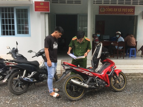 Công an xã Phú Đức (huyện Long Hồ) thực hiện các thủ tục cấp biển số xe mô tô cho người dân.