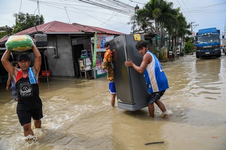 Người dân tỉnh Bulacan (Philippines) mang theo đồ đạc đi sơ tán - Ảnh: AFP