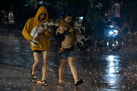  Người dân thành phố Marikina đưa thú cưng đi sơ tán giữa cơn mưa - Ảnh: AFP