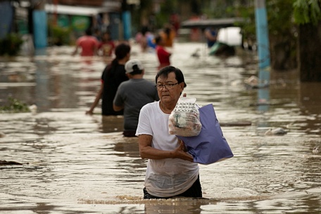 Người dân tỉnh Bulacan lội nước sâu tới thắt lưng - Ảnh: REUTERS