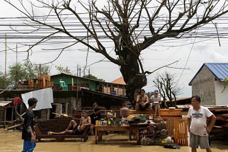  Người dân sơ tán khỏi nhà bị ngập trong nước lũ tại cộng đồng San Ildefonso, tỉnh Bulacan, Philippines - Ảnh: REUTERS