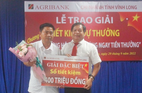  Đại diện lãnh đạo Agribank Vĩnh Long trao giải đặc biệt cho khách hàng may mắn.