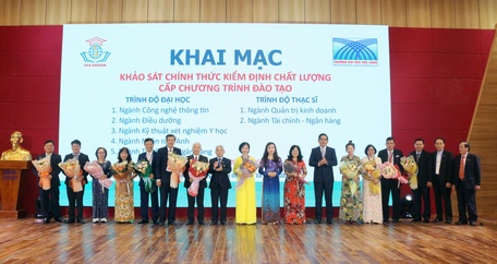 Trường ĐH Cửu Long tặng hoa cho các thành viên Trung tâm Kiểm định chất lượng giáo dục Sài Gòn tại lễ khai mạc.