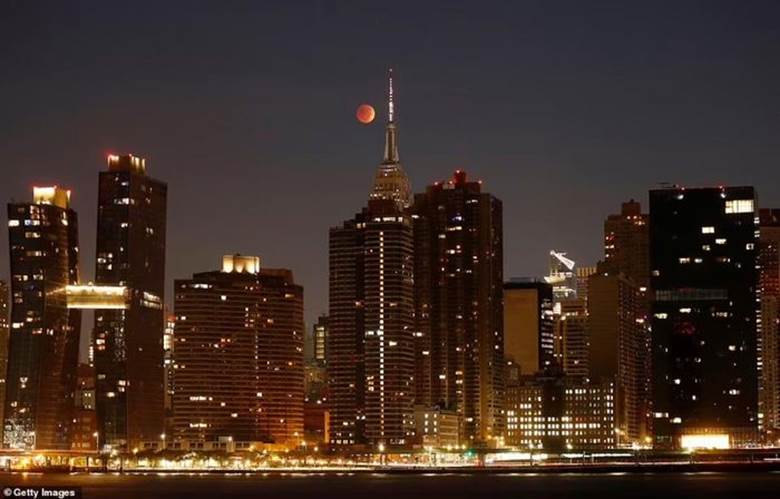 Hiện tượng trăng máu kéo dài khoảng 90 phút, sau đó mặt trở lại màu bạc sáng. Trong ảnh, mặt trăng xuất hiện đằng sau tòa nhà Empire State ở New York, Mỹ. Ảnh: Getty