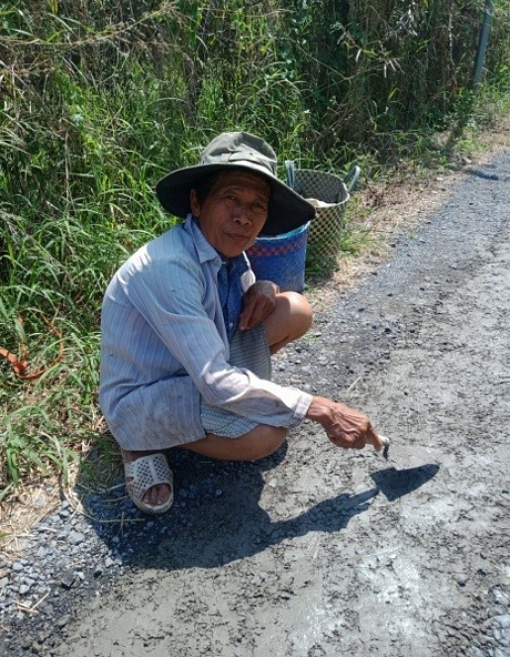 Ông Nguyễn Văn Ngộ tranh thủ thời gian nghỉ trưa để vá đường (ảnh chụp lúc 11giờ 30 ngày 10/11/2022).