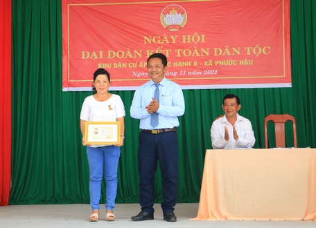 Bí thư Huyện ủy Hồ Văn Minh trao Kỷ niệm chương “Vì sự nghiệp đại đoàn kết toàn dân tộc” cho chị Võ Kim Nhuận.