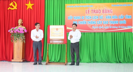 Phó Giám đốc Sở Văn hóa – TT – DL Lê Thanh Hiền (trái) trao bằng xếp hạng di tích cho đại điện UBND xã Thạnh Quới.