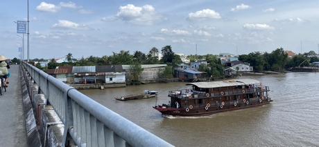 Từ cầu Trà Ôn nhìn về TT Trà Ôn - thị trấn bên dòng sông Hậu và sông Măng Thít. Trong ảnh: Tàu du lịch đi ngang cầu Trà Ôn trên sông Măng Thít.