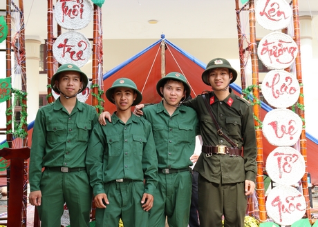 Tạm gác việc học, tân binh Võ Thành Đạt (phải) cùng các tân binh phấn khởi lên đường thực hiện nhiệm vụ của thanh niên.