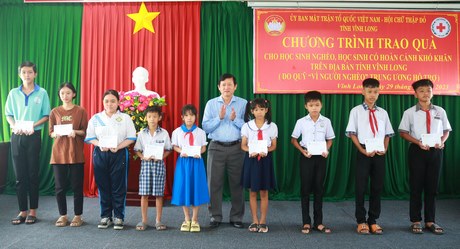 Chủ tịch Ủy ban MTTQ Việt Nam tỉnh- Hồ Văn Huân trao học bổng cho các em học sinh.