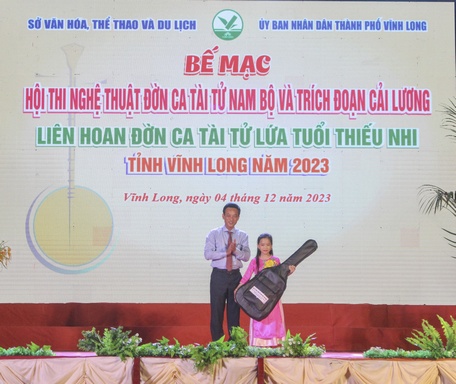 Em Ngô Thị Kim Ngân nhận phần thưởng là cây đàn guitar khi tham dự Đờn ca tài tử lứa tuổi thiếu nhi