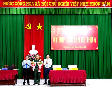 Ông Bùi Văn Nở- Bí thư Thành uỷ (bìa phải) và ông Đặng Văn Lượng- Chủ tịch UBND thành phố tặng hoa chúc mừng ông Trương Văn Đặng.