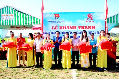 Các đại biểu thực hiện nghi thức cắt băng khánh thành công trình sân thể thao cộng đồng tại ấp Mỹ Phú (xã Mỹ Lộc, huyện Tam Bình).